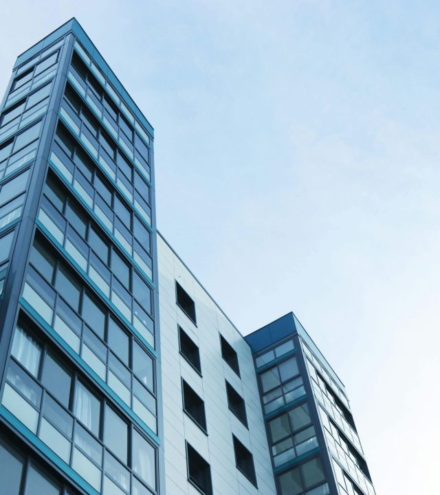 Low-angle view of a modern glass skyscraper against a clear sky in Poole, UK.